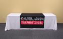 This custom table runner clearly displays a multi-colour company logo with gradient on a printed black background (shown on a 8' white covered table - not included)