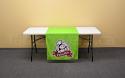 This eye catching 30 inch x 60 inch table runner is custom printed with a multi colour logo and special pantone bright green colour background